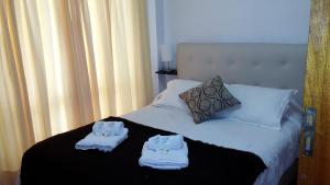 门多萨Departamentos El Ceibo II的一间卧室配有带毛巾的床