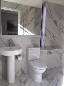 悉尼KC伊丽莎白湾公寓的白色的浴室设有卫生间和水槽。