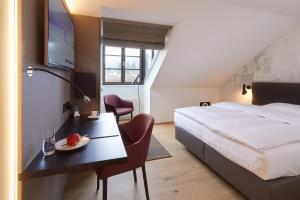 阿尔勒斯海姆奥斯森酒店的酒店客房设有一张床和一张带果盘的桌子。