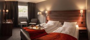 奥塔Thon Partner Hotel Otta的酒店客房设有一张大床和木制床头板