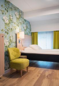 滕斯贝格滕斯贝格布莱格松恩酒店的一间卧室配有一张床和一张黄色椅子