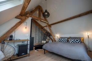东弗利兰Loods Logement的卧室配有一张床铺,位于带木梁的房间