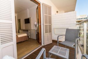阿尔库迪亚港Eix Alcudia Hotel Adults Only的客房设有带椅子和床的阳台。