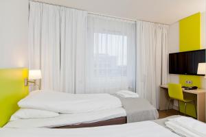 奥斯陆MediInn Hotel Oslo的酒店客房设有两张床和一台平面电视。