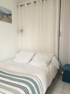 滨海沃博泰拉克公园公寓的一张带白色床单和蓝色及白色毯子的床