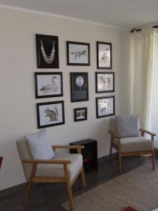 普孔Departamento en Pucon的客厅配有两把椅子,墙上挂有图片