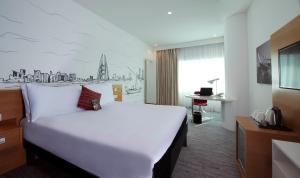 麦纳麦ibis Styles Manama Diplomatic Area的酒店客房设有一张白色大床和一张书桌