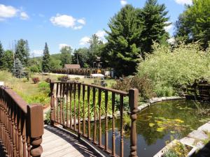 DwightDwight Riverside Inn的花园池塘上的木桥