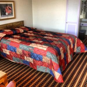 Shelby瑞莱克斯酒店 - 谢尔比的一间卧室配有一张带五颜六色被子的床
