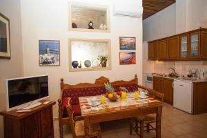 阿瑞罗波利斯艾纳萨公寓式酒店的一间厨房,内设桌子和一台电视机