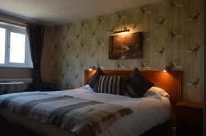 斯卡伯勒Orchard Lodge & Wolds Restaurant的卧室配有一张床,墙上挂有绘画作品