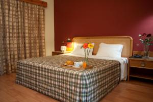 旧阿尔贝加里亚瑞贝罗特尔酒店的一间酒店客房,配有一张带鲜花托盘的床