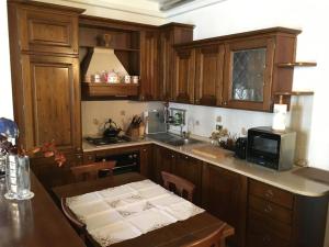 米兰套房（卧室和客厅）公寓的厨房配有木制橱柜和带微波炉的桌子。