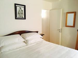 米兰套房（卧室和客厅）公寓的一间卧室配有一张带白色床单和镜子的床