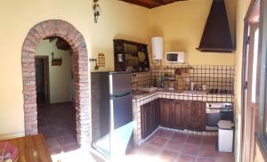 巴列埃尔莫索Casa Rural Vicente的带冰箱和拱门的厨房