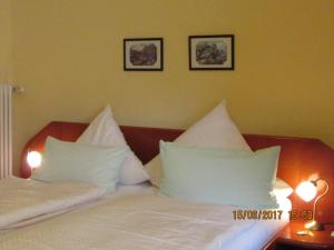 新基兴Neuenkirchener Hof的卧室配有2个白色枕头