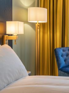 斯沃尔韦尔罗弗敦索恩酒店的一间卧室配有两盏灯和一把蓝色椅子