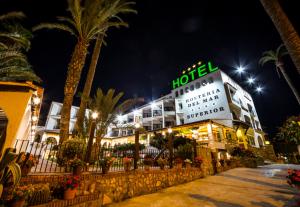 佩尼斯科拉海滨旅馆的一家在晚上拥有棕榈树的酒店