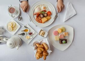 乌兰巴托蓝天大厦酒店的一张桌子,上面放着两盘早餐食品和咖啡