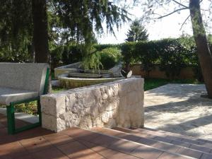 阿尔贝罗贝洛阿斯托利亚酒店的一个带长凳和石墙的公园