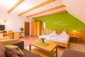 菲尔斯滕费尔德附近洛伊佩尔斯多夫Birkenhof Loipersdorf的一间卧室设有一张大床和绿色的墙壁