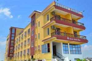 菩提伽耶Hotel Bodh Vilas的黄色的建筑,带有红色的阳台