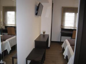 拉科鲁尼亚Suites Coruña的客房设有两张床、一张桌子和镜子