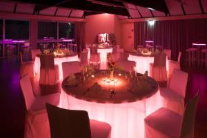 赖兴瑙Parkhotel Hirschwang的一间设有白色桌椅和紫色灯的房间