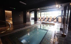 曼彻斯特水边酒店和休闲俱乐部的一个带椅子的房间的大型游泳池