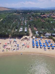 玛里纳蒂蒙内罗Maronda Camping的享有海滩的空中景致,配有遮阳伞和椅子