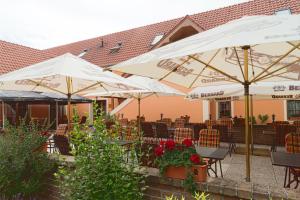 巴甫洛夫巴甫洛夫酒店的庭院配有白色遮阳伞和桌椅。