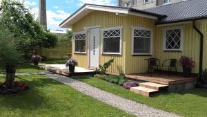 哈普萨卢Haavalehe Summer House的一座黄色的小房子,设有木甲板