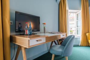 博讷乐中心精品酒店的客房设有书桌、电视和椅子