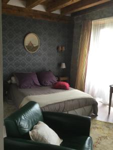 La Chaze-de-PeyreLa ferme de Félix的一间卧室配有一张床、一张沙发和一把椅子
