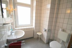 德累斯顿波克酒店的一间带水槽和卫生间的浴室以及窗户。