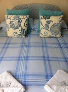 赖德桃源岛别墅酒店的一张带蓝色和白色床单及枕头的床