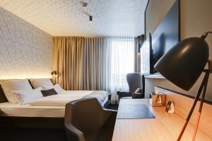 多特蒙德NYCE Hotel Dortmund City的配有一张床和一张书桌的酒店客房