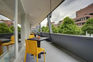 多特蒙德NYCE Hotel Dortmund City的美景阳台配有桌椅