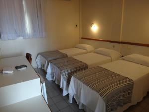 阿拉卡茹简加德罗酒店的一间酒店客房,房间内设有三张床