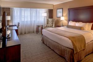 布里奇顿Crowne Plaza Hotel St. Louis Airport, an IHG Hotel的酒店客房带一张大床和一把椅子