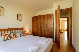 莱斯卡拉Costabravaforrent Masferrer的卧室配有白色的床和木制床头板