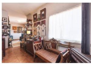 马尔科-德卡纳维泽斯Land Story - Rural House的客厅配有长凳、书桌和窗户。