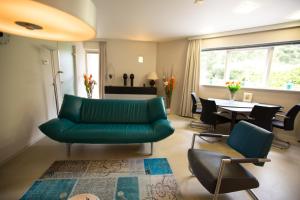 阿珀尔多伦Xenith Gastenverblijf的客厅配有绿色沙发和椅子