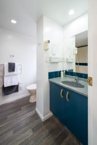 基督城安娜贝尔阁汽车旅馆的浴室配有蓝色水槽和卫生间。