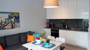 尤斯托尼莫斯基APD Apartments - Rezydencja Ustronie Morskie的厨房以及带沙发和桌子的客厅。