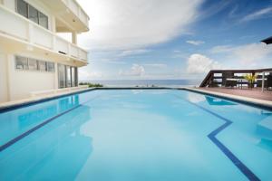 拉罗汤加Mai'I Villa Apartments的一座背景海洋的游泳池