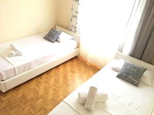 卡瓦拉Sweet Rooms Kavala的铺有木地板的客房内配有2张白色的床