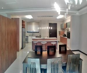 哈博罗内Lifestyle Apartments的一个带桌椅的大厨房