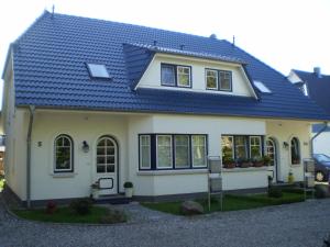 青斯特Ferienwohnung Strandmuschel的蓝色屋顶的白色房子