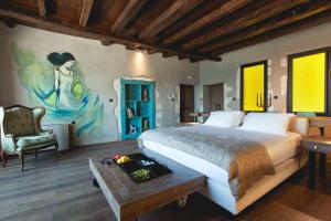 干尼亚Chania Inn的卧室配有一张床,墙上挂有绘画作品